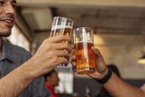 Two friends clinking beers in Byron Bay Bar